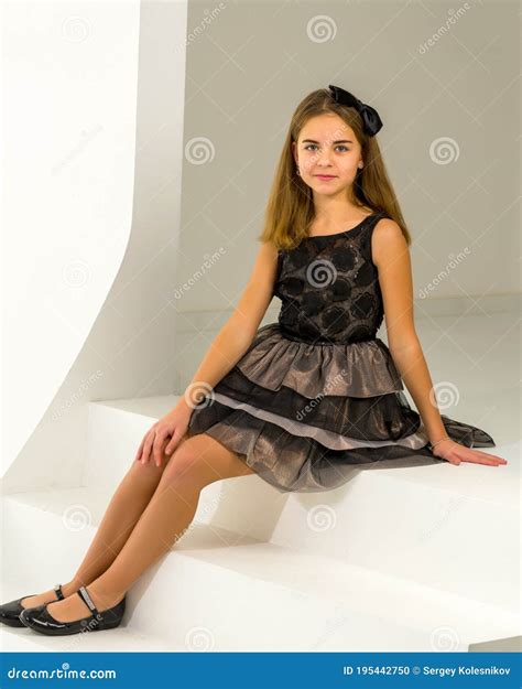 Cute Little Girl is Sitting in the Studio on the White Stairs. Style and Fashion Concept, Happy ...