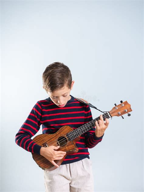 Happy Young Boy Playing The Ukelele Stock Image - Image of cute, children: 196770781