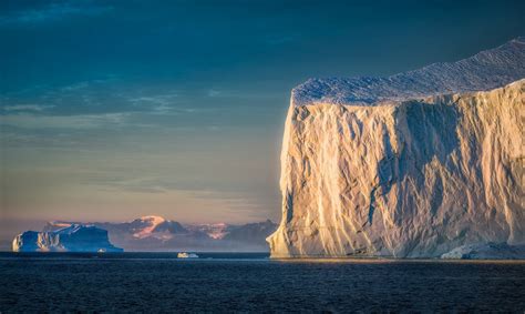 A giant iceberg greeting the sun on an early morning in Eastern Greenland | by hpd-fotografy ...