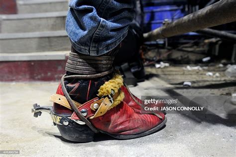 A professional bull rider wearing cowboy boots with spurs waits to... News Photo - Getty Images