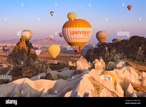 Flying hot air balloons and rock landscape at sunrise time in Goreme ...