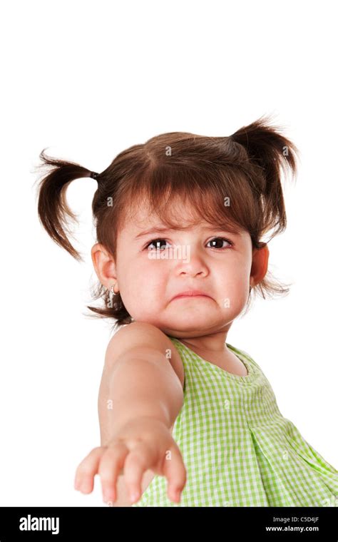 Cute baby toddler young little girl with very sad face expression reaching out for help ...