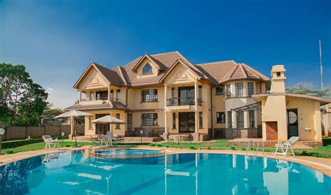 a large house with a swimming pool in the front yard and lawn furniture around it