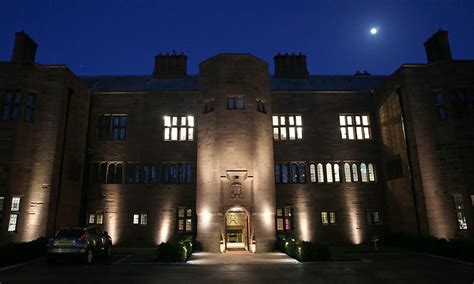 a large building lit up at night with the moon in the sky