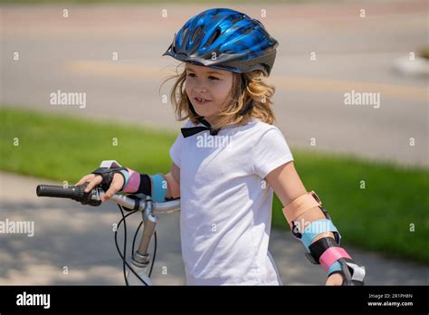 Kid riding bike on a summer park. Child in safety helmet riding bike ...