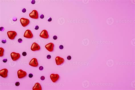 Pink background with shiny candies in the shape of hearts. 23551996 Stock Photo at Vecteezy