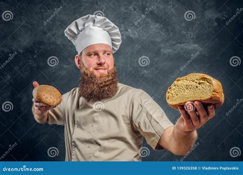 Cheerful Bearded Baker Wearing a Uniform Showing His Freshly Made Bread ...