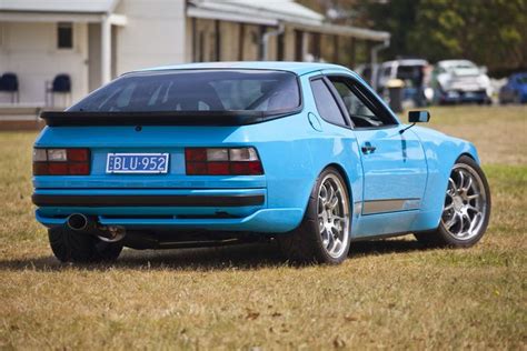 a blue car parked on top of a grass covered field