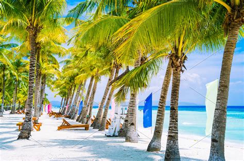 Tropical beach at Panglao Bohol island with chairs on the white sand beach with blue sky and ...