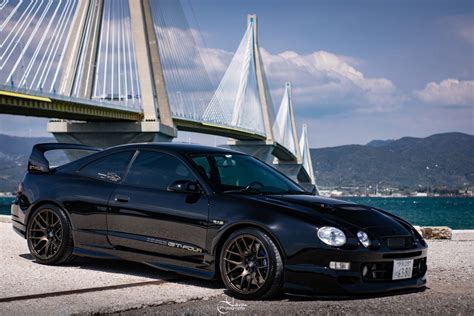 a black sports car parked in front of a bridge