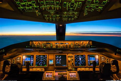 the cockpit of an airplane at night with illuminated screens and lights on it's windows