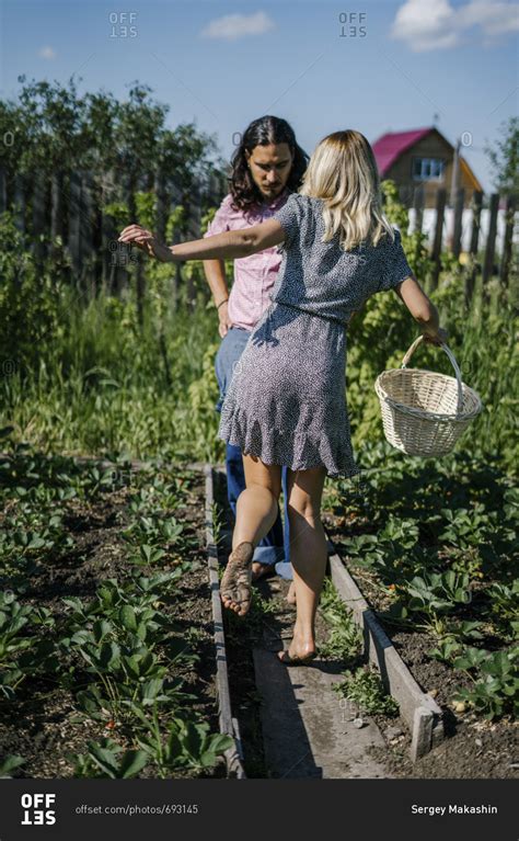 Couple walking barefoot in a garden stock photo - OFFSET