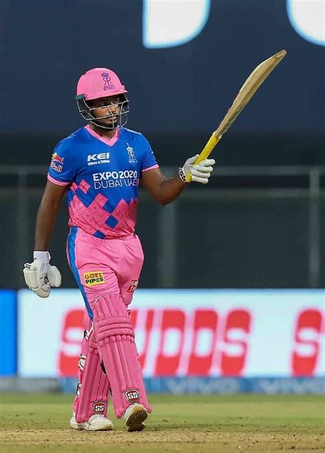 a man in pink and blue uniform holding a bat