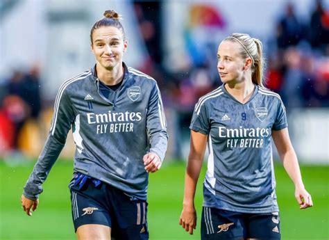 two female soccer players are walking on the field