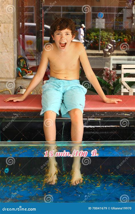 Boy Undergo Fish Pedicure Procedure Stock Photo | CartoonDealer.com #70041679