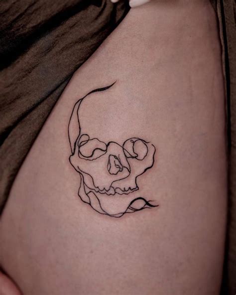 Abstract skull tattoo located on the pelvis.