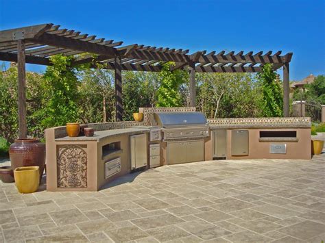 an outdoor kitchen with grill and seating area