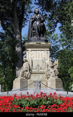 Vondelpark Amsterdam. The statue of playwright Joost van den Vondel with orange tulips and ...