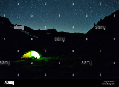 Illuminated tent on silhouette mountain at night Stock Photo - Alamy