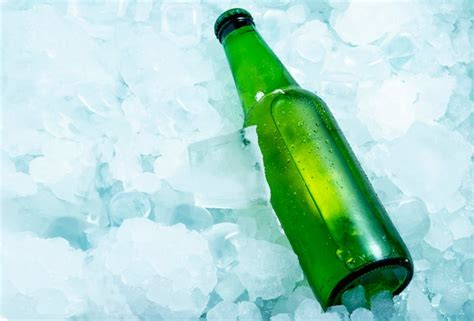 Premium Photo | Bottle of green beer in very cold ice cubes horizontal