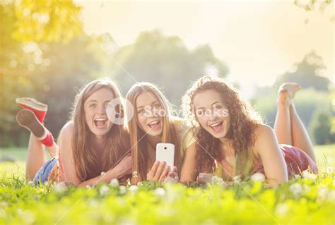 Three friends enjoying a sunny day in the park Royalty-Free Stock Image - Storyblocks