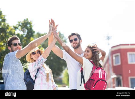 Hip friends doing high-five Stock Photo - Alamy