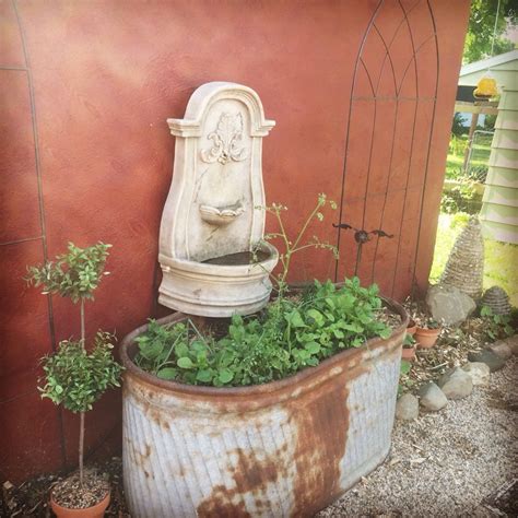 Galvanized rusty horse trough with a water fountain in the courtyard of ...