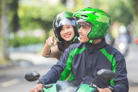 Premium Photo | Motorcycle taxi driver taking his passenger to her destination