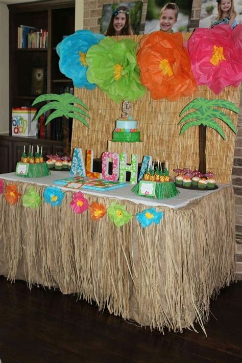 an image of a birthday party with decorations on the table and palm trees in the background