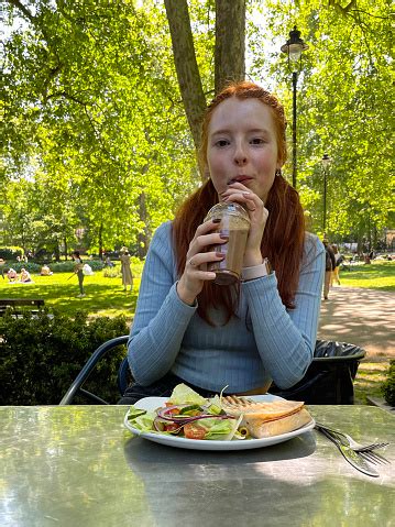 Image Of Attractive Redheaded Woman Drinking Iced Coffee Through Straw From Plastic Disposable ...