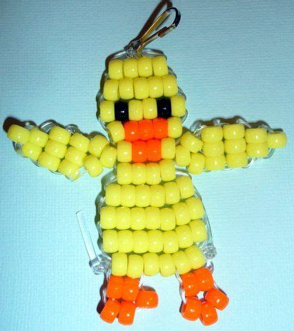 a plastic key chain with an orange and yellow bird on it's head, made out of beads