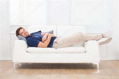 Man Lying On Sofa At Home Stock Photo by ©AndreyPopov 71491863