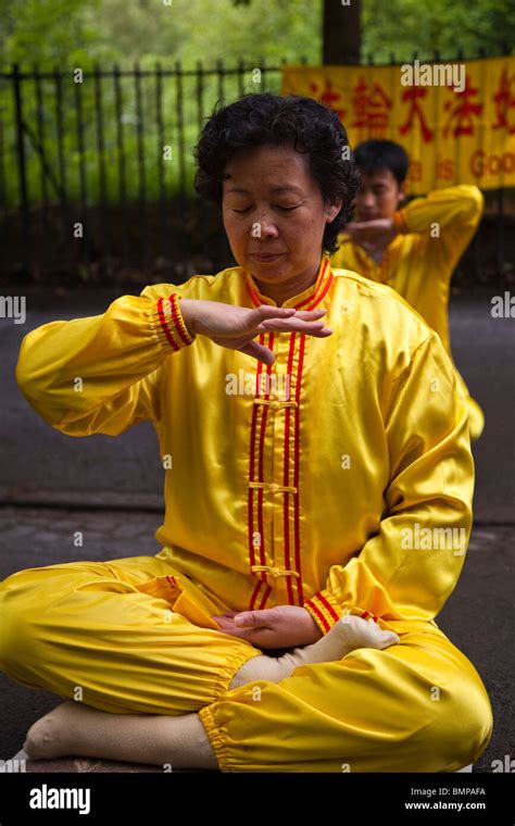 Woman practising Falun Gong, a form of Chinese meditation exercises in a position known as ...