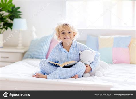 Child reading book in bed. Kids read in bedroom. Stock Photo by ...