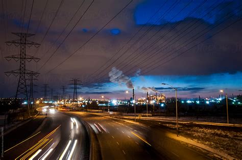 "Large Highway Through Urban Industrial Zone At Night" by Stocksy Contributor "JP Danko" - Stocksy