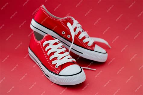 Premium Photo | Fashionable red sneakers with white laces on red background