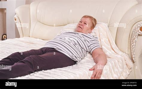 Elderly woman on bed with back pain Stock Photo - Alamy