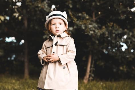 Premium Photo | Stylish baby girl wearing trendy trench outdoors