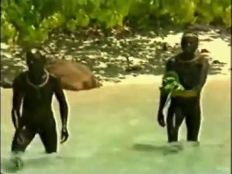 two men in wetsuits are walking through the water