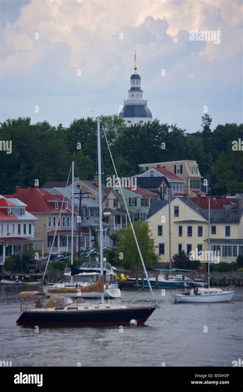 Sailboats moored along the Annapolis waterfront with the historic state capital building in the ...