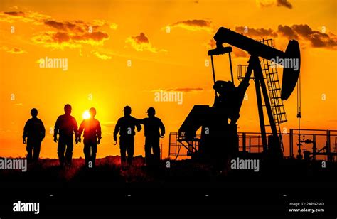 Silhouette of a oilfield worker crude oil pump at sunset Stock Photo ...