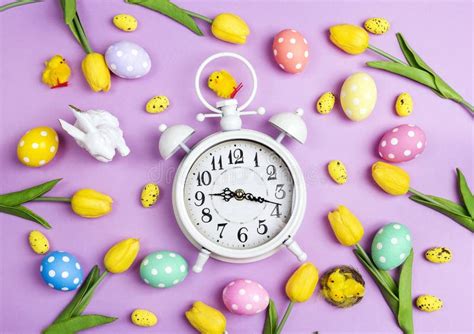 Easter Alarm Clock with Colorful Eggs and Tulips on Purple Background. Stock Image - Image of ...