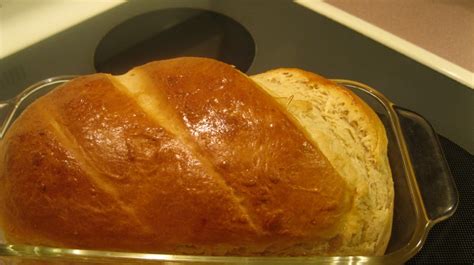 a loaf of bread sitting on top of a glass pan next to an oven burner