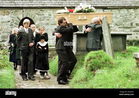 Dr Shaun Russell and daughter Josie follow one of the two coffins to their final resting place ...