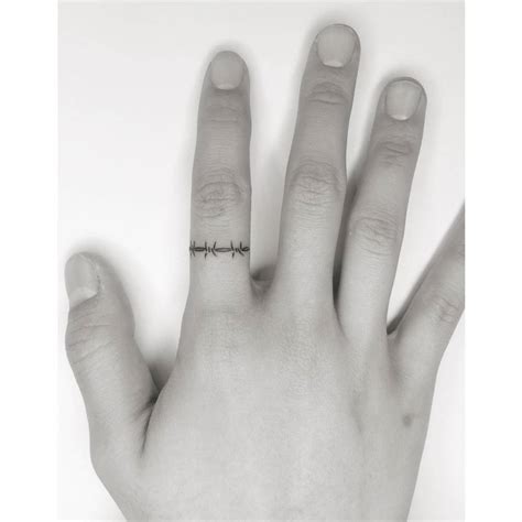 Minimalistic style barbed wire ring tattoo.