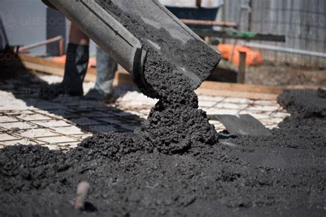 Image of Coloured concrete pouring out of cement truck chute - Austockphoto