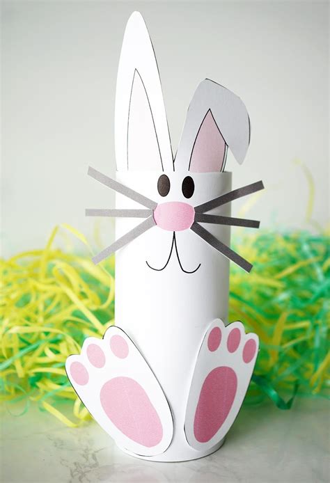 an easter bunny made out of paper sitting on top of some yellow and ...