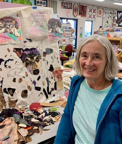 an older woman standing in front of a table full of crafting supplies and paper