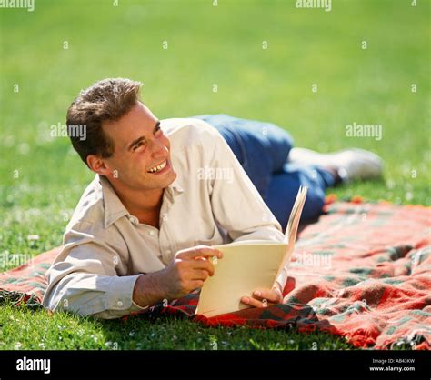 Man outdoors reading book Stock Photo - Alamy