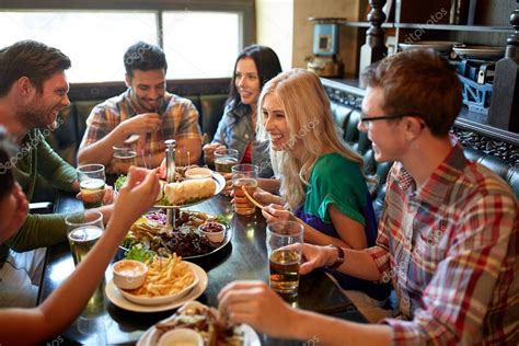 friends dining and drinking beer at restaurant — Stock Photo © Syda_Productions #130478884